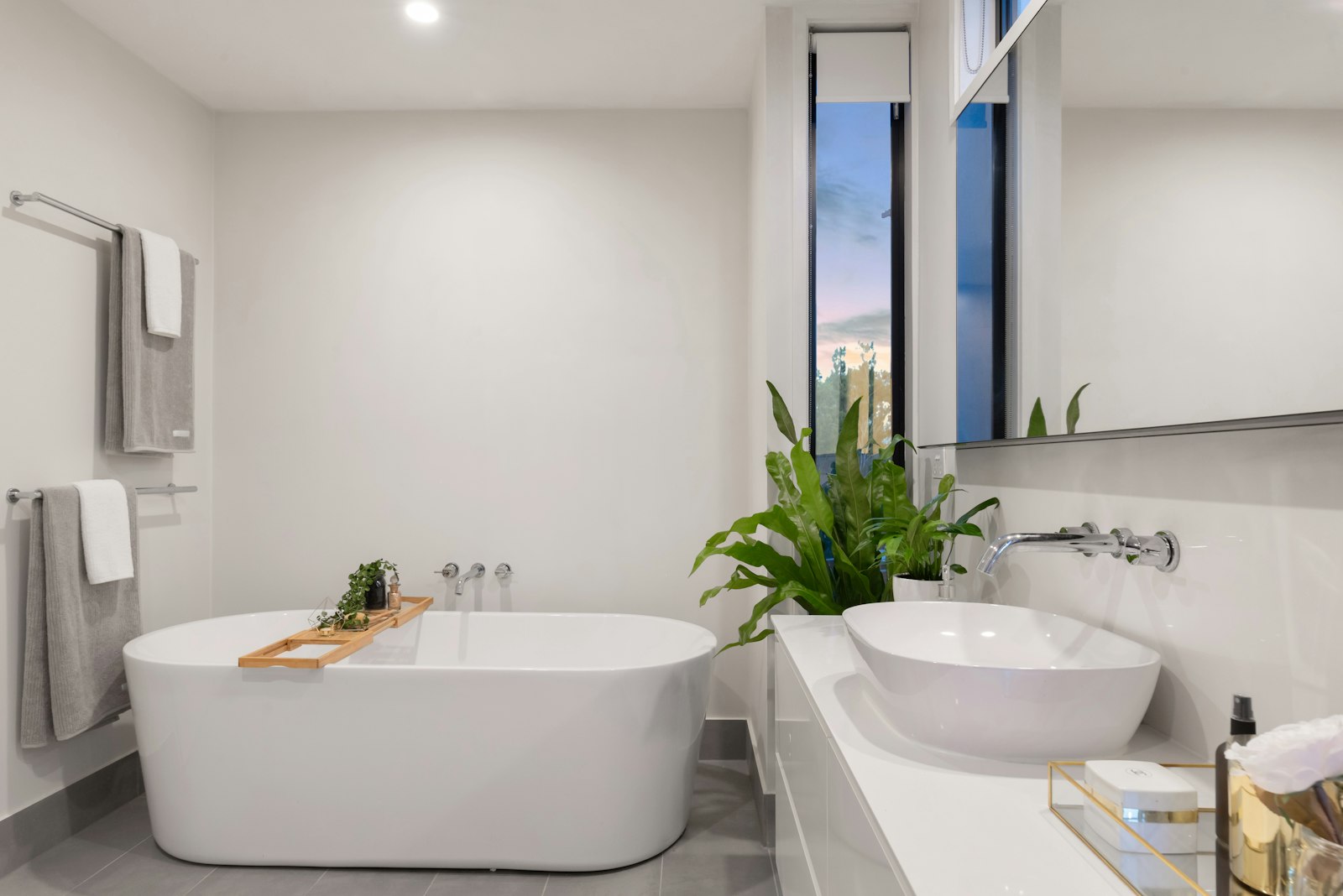 Helles Wellnessbad mit freistehender Badewanne und Aufsatzwaschbecken